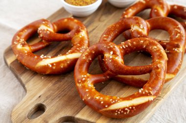 Tahta üzerinde hardal olan ev yapımı yumuşak Bavyera krakerleri..