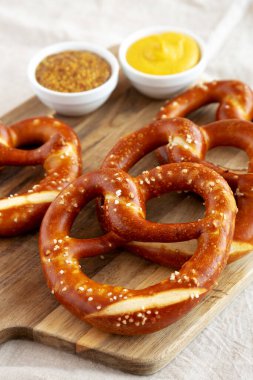 Tahta üzerinde hardal olan ev yapımı yumuşak Bavyera krakerleri.. 