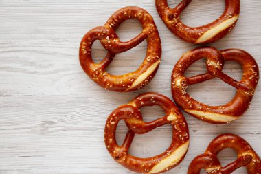 Beyaz ahşap arka planda ev yapımı yumuşak Bavyera krakerleri, üst manzara. Boşluğu kopyala.