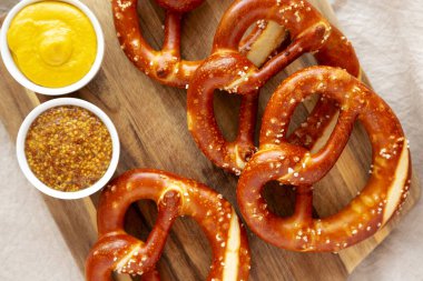 Tahta üzerinde hardal olan ev yapımı yumuşak Bavyera krakerleri..