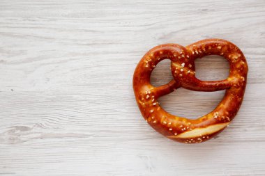 Beyaz ahşap arka planda ev yapımı yumuşak Bavyera krakeri. Boşluğu kopyala.