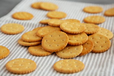 Gri arka planda deniz tuzu olan yuvarlak çıtır krakerler, düşük açı manzaralı.. 