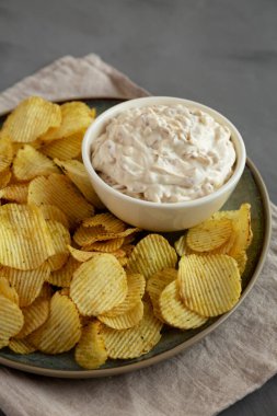 Kıtır kıtır patates cipsi ve Fransız soğan sosu tabağa batırılmış, yan manzara..