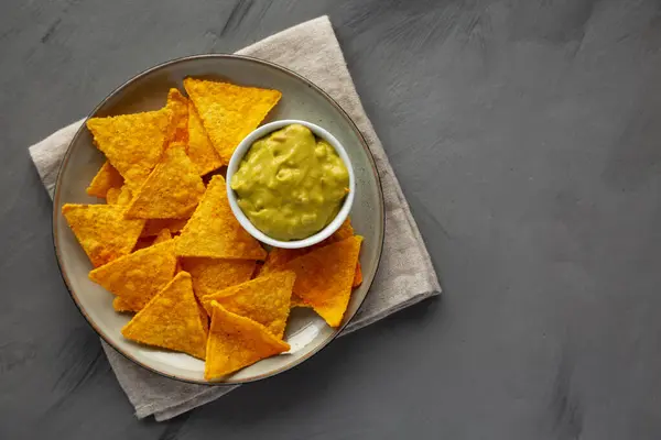 Tabakta Tortilla Chips ve ev yapımı Guacamole, en iyi manzara. Dümdüz, tepeden, yukarıdan.