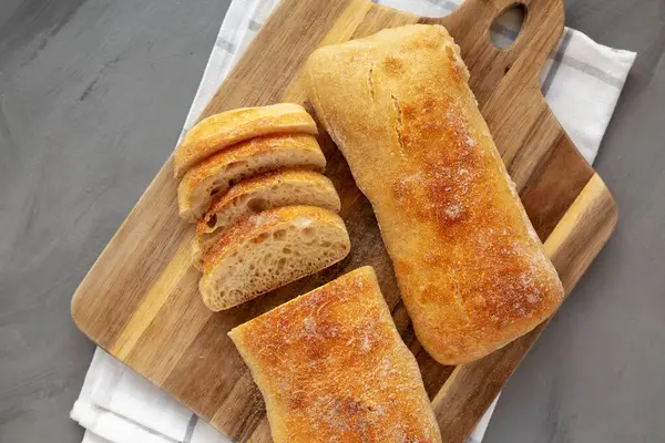 Tahta bir tahtanın üstünde ev yapımı Ciabatta Ekmeği, üst manzara. Dümdüz, tepeden, yukarıdan.