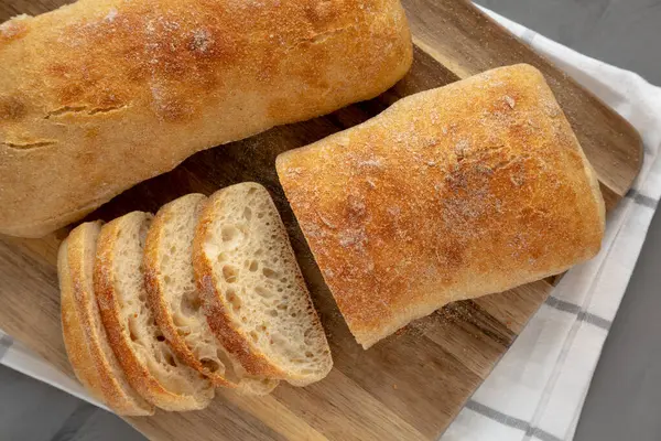 Tahta bir tahtanın üstünde ev yapımı Ciabatta Ekmeği, üst manzara. Dümdüz, tepeden, yukarıdan. 