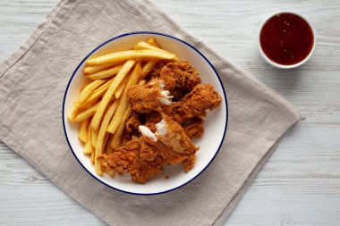 Kızarmış patates ve ekşi soslu çıtır tavuk şeritleri.