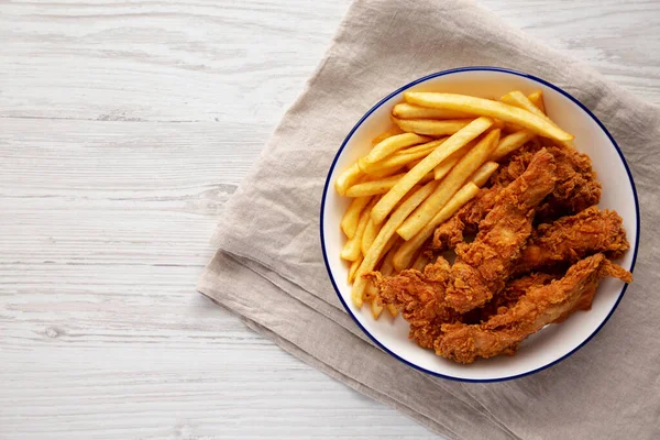 Crispy Chicken Strips with French Fries on a Plate, top view. Copy space.