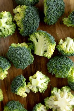 Tahta üzerinde organik çiğ brokoli çiçekleri, üst manzara. Dümdüz, tepeden, yukarıdan. Yakın plan..