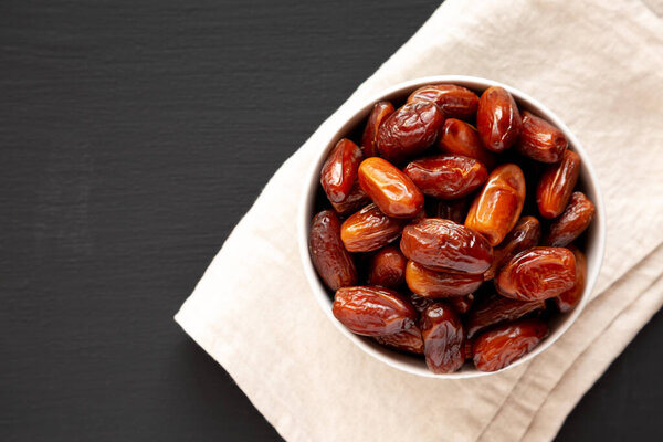 Organic Dry Deglet Nour Dates in a Bowl, top view. Space for text.