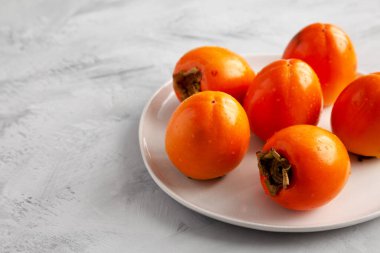 Gri arka planda, plaka üzerinde organik hurma ağacı meyvesi. Boşluğu kopyala.