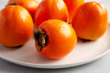 Gri arka planda, plaka üzerinde organik hurma ağacı meyvesi. Yakın plan..