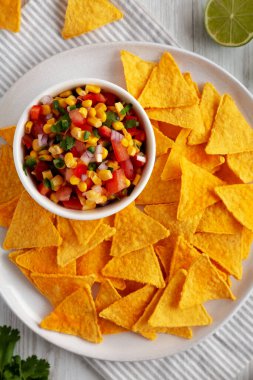 Ev yapımı Mısır Salsa 'sı ve bir tabak Tortilla Chips, en iyi manzara. Yukarıdan, dümdüz uzanmış.