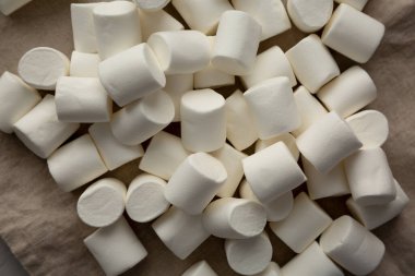 Kumaş üzerinde beyaz şekerlemeler, üst manzara. Dümdüz, tepeden, yukarıdan.