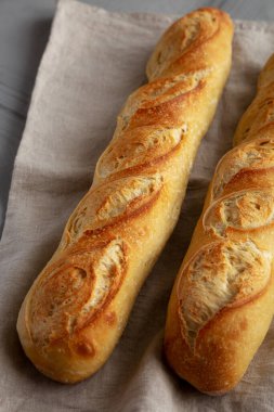 Gri arka planda ev yapımı Fransız Ekmek Bageti, yan görünüm.
