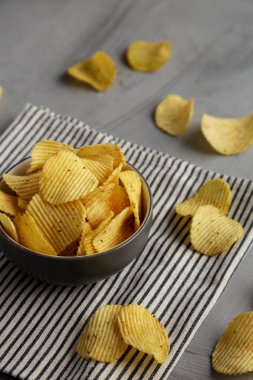 Organik Buruşuk Ekşi Krema ve Soğan Patates Cipsi Bir kâsede, yan görünüm.