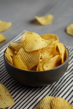 Organik Buruşuk Ekşi Krema ve Soğan Patates Cipsi Bir kâsede, yan görünüm.