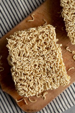 Ahşap bir tahtanın üstünde kuru Ramen Eriştesi, üst manzara. Yakın plan..