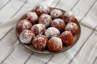 Tabakta pudra şekerli ev yapımı kızarmış çörek delikleri, yan manzara..