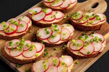 Ev yapımı limonlu turplu tart tahtada siyah arka planda, yan görünüşte..