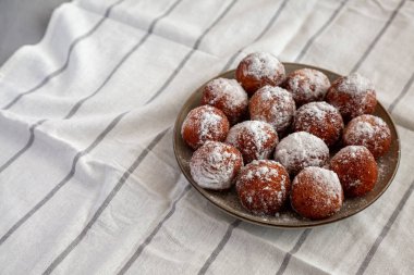 Tabakta pudra şekerli ev yapımı kızarmış çörek delikleri, yan manzara..