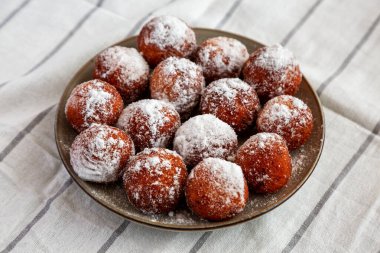 Tabakta pudra şekerli ev yapımı kızarmış çörek delikleri, yan manzara..