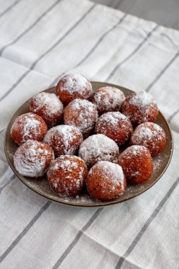 Tabakta pudra şekerli ev yapımı kızarmış çörek delikleri, yan manzara..