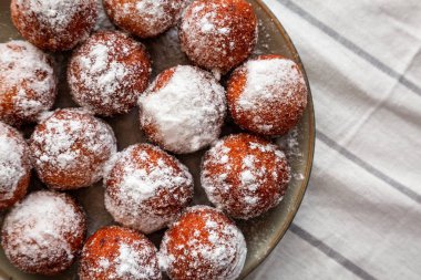 Tabakta pudra şekerli ev yapımı kızarmış donut delikleri..