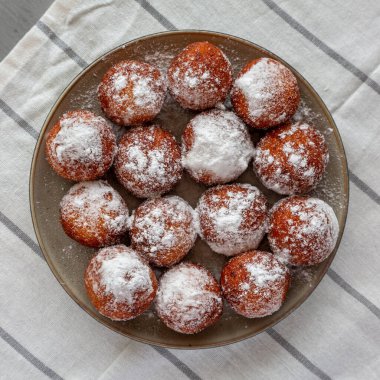 Tabakta pudra şekerli ev yapımı kızarmış donut delikleri..
