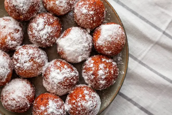 Tabakta pudra şekerli ev yapımı kızarmış donut delikleri..