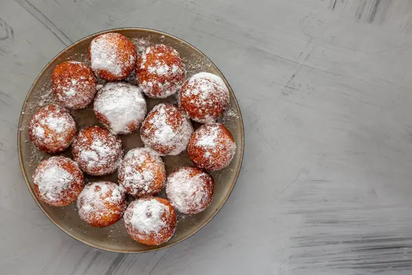 Tabakta pudra şekerli ev yapımı kızarmış çörek delikleri, üst manzara. Boşluğu kopyala.