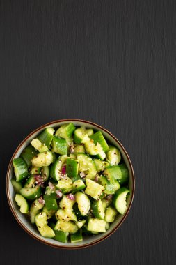 Ev yapımı, siyah arka planda salatalık ezme salatası, üst manzara. Metin için boşluk.