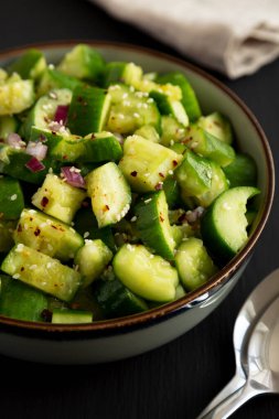 Ev yapımı, siyah arka planda salatalık ezilmiş salata.. 