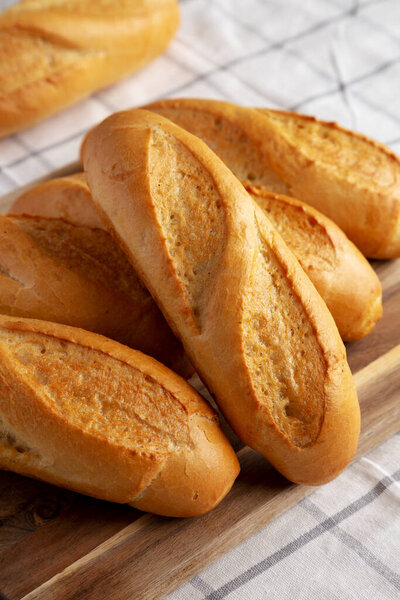 Homemade Mini baguettes on a wooden board, side view. Close-up.