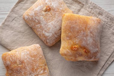 Beyaz ahşap arka planda ev yapımı Cheese Ciabatta çörekleri, üst manzara. Yakın plan..