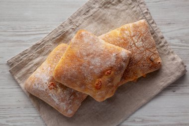 Beyaz ahşap arka planda ev yapımı Cheese Ciabatta çörekleri, üst manzara. Boşluğu kopyala.