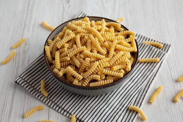 stock image Raw Dry Organic Italian Fusilli Corti Bucati in a Bowl, side view.