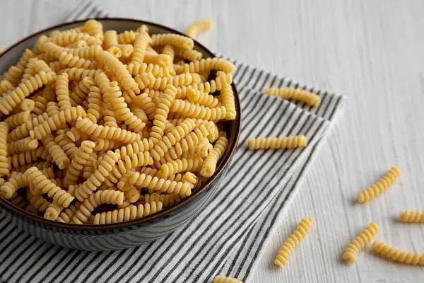 stock image Raw Dry Organic Italian Fusilli Corti Bucati in a Bowl, side view.