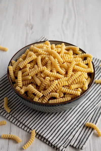 stock image Raw Dry Organic Italian Fusilli Corti Bucati in a Bowl, side view.