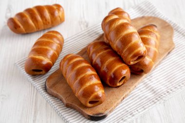 Ev yapımı Kolache Rolls on a rustic wood board, side view.