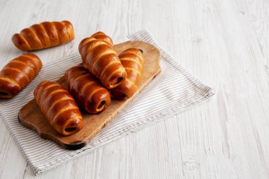 Ev yapımı Kolache Rolls on a rustic wood board, side view.