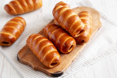 Ev yapımı Kolache Rolls on a rustic wood board, side view.