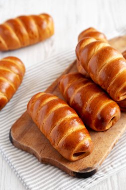 Ev yapımı Kolache Rolls on a rustic wood board, side view.