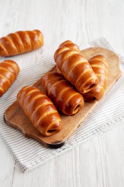 Ev yapımı Kolache Rolls on a rustic wood board, side view.