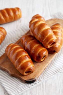 Ev yapımı Kolache Rolls on a rustic wood board, side view.
