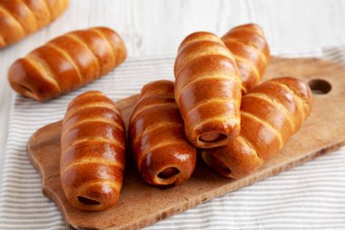 Ev yapımı Kolache Rolls on a rustic wood board, side view.