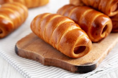 Ev yapımı Kolache Rolls on a rustic wood board, side view.