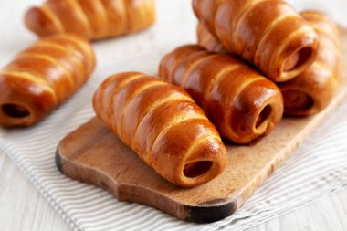 Ev yapımı Kolache Rolls on a rustic wood board, side view.
