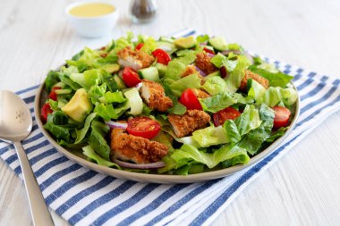 Tabakta domates ve salatalıklı ev yapımı çıtır tavuk salatası. Yakın plan..