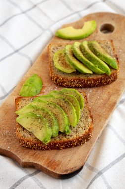 Ev yapımı Avokado tostu, ahşap tahtada tuz ve biberli, yan manzaralı..